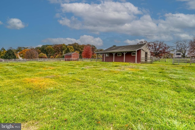 view of yard featuring a rural view and an outdoor structure