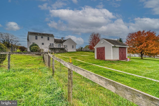 view of yard featuring a storage unit, a rural view, and a wooden deck