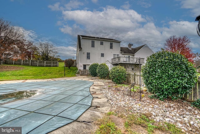 back of house with a yard, a patio, and a covered pool