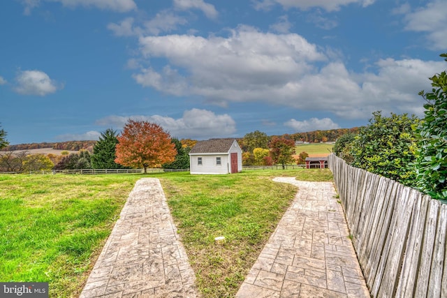 view of yard featuring a rural view and a storage shed