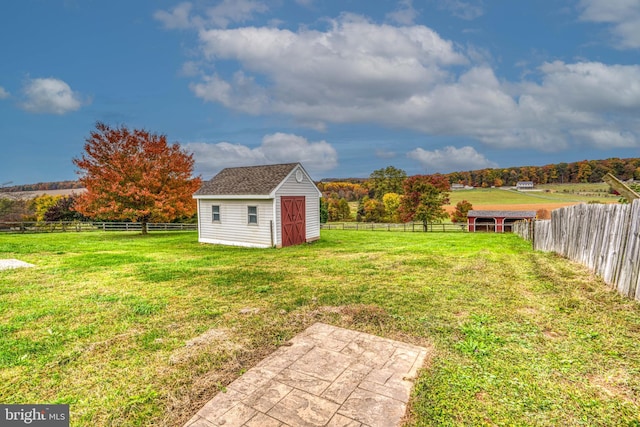 view of yard featuring a rural view and a shed