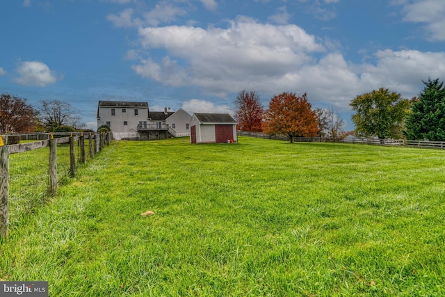 view of yard featuring a rural view and a storage shed