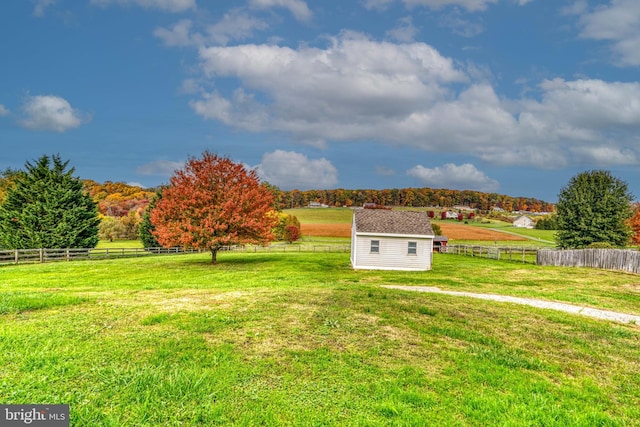 view of yard with a rural view and an outdoor structure