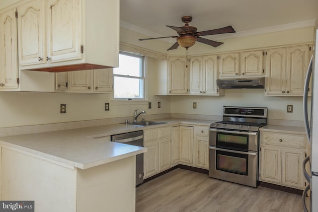 kitchen with kitchen peninsula, appliances with stainless steel finishes, light wood-type flooring, crown molding, and sink