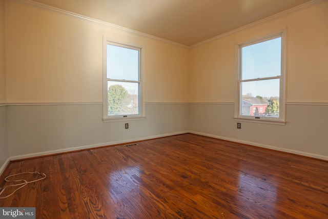 spare room with plenty of natural light, crown molding, and dark wood-type flooring