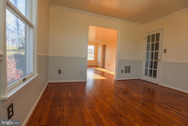 spare room featuring wood-type flooring, plenty of natural light, and crown molding