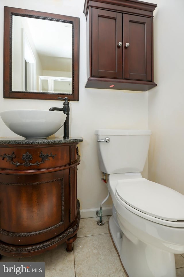 bathroom featuring toilet, vanity, and tile patterned floors