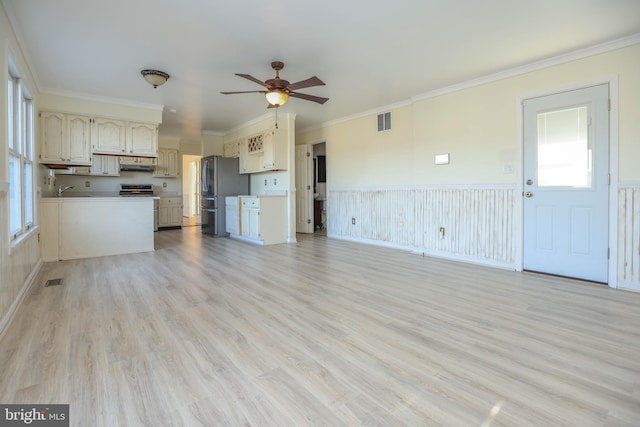 unfurnished living room featuring ceiling fan, light hardwood / wood-style floors, and ornamental molding