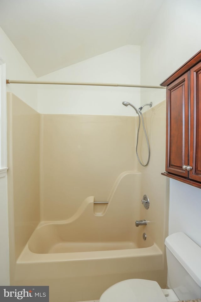 bathroom with shower / tub combination, toilet, and lofted ceiling