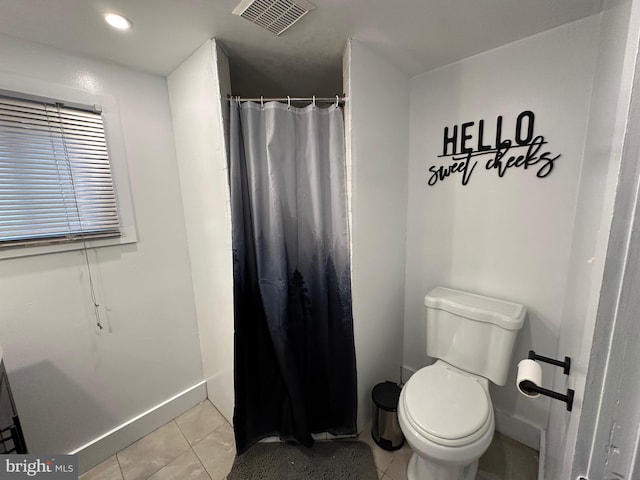 bathroom featuring tile patterned flooring, toilet, and walk in shower