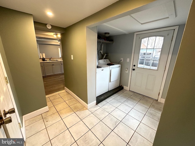 clothes washing area featuring washing machine and dryer, sink, and light tile patterned floors