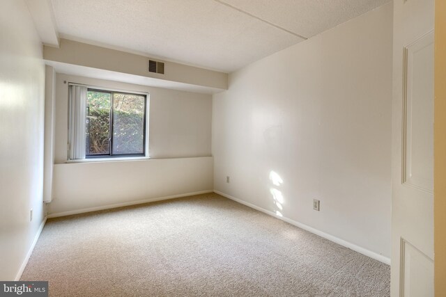 spare room with a textured ceiling and carpet floors