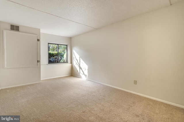 empty room featuring carpet and a textured ceiling