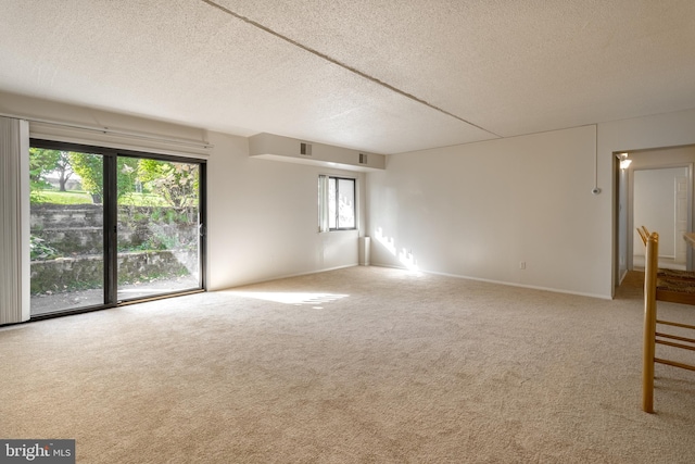 unfurnished room with carpet flooring and a textured ceiling