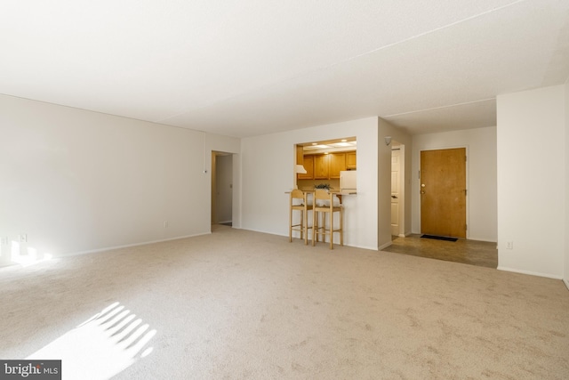 unfurnished living room featuring light colored carpet