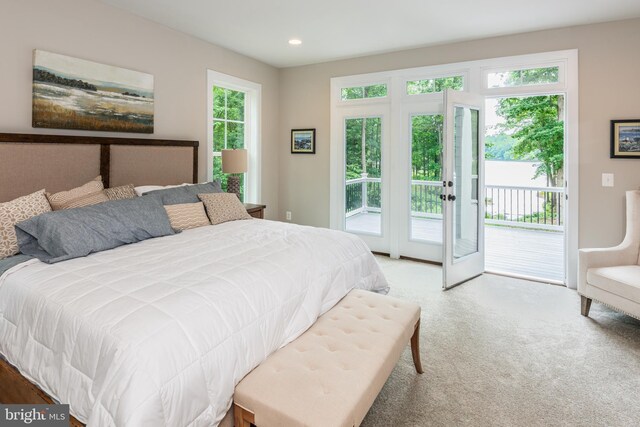 carpeted bedroom featuring french doors, access to outside, and multiple windows