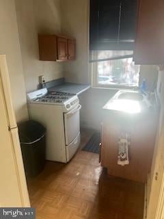 kitchen with white range with gas cooktop and light parquet flooring