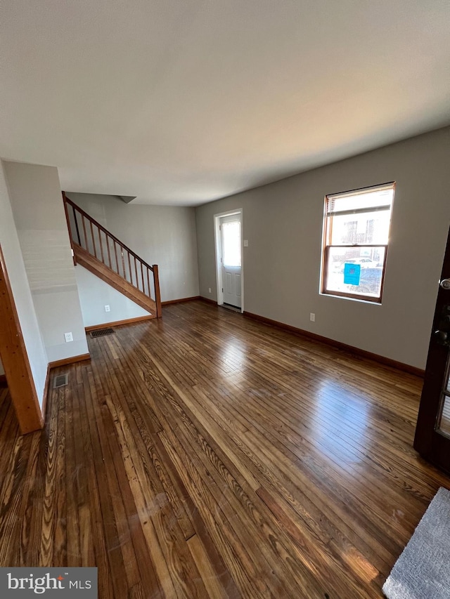 unfurnished living room featuring dark hardwood / wood-style floors