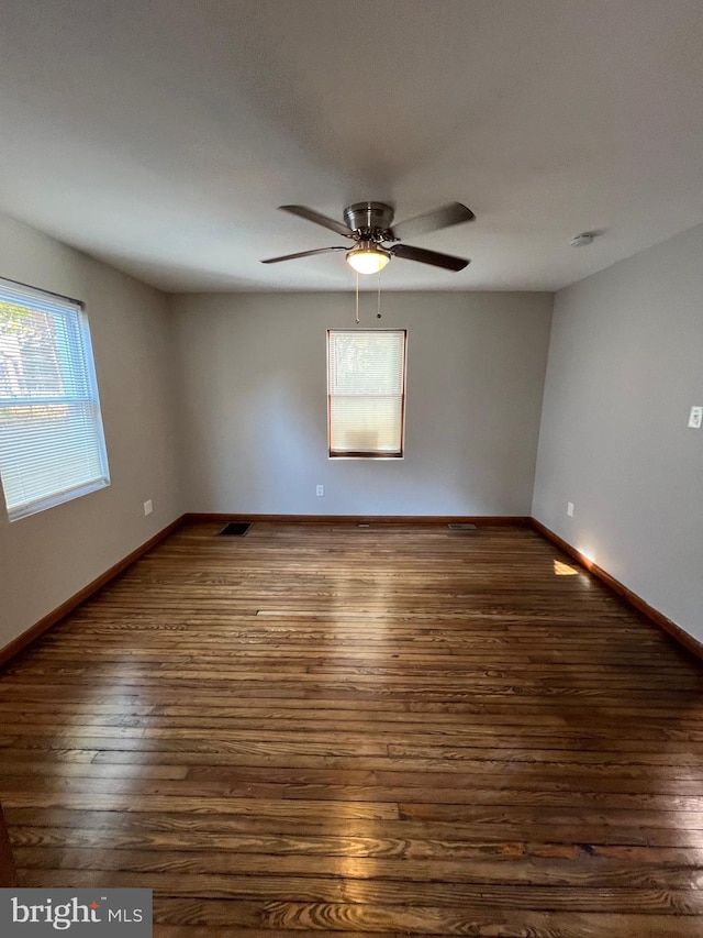 unfurnished room with dark hardwood / wood-style flooring, ceiling fan, and a healthy amount of sunlight