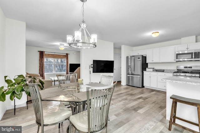 dining area with a chandelier and light wood-type flooring