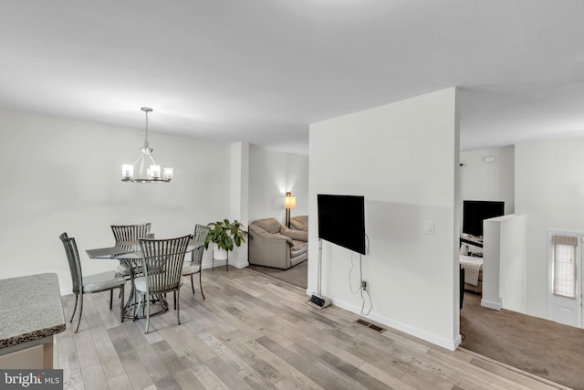 dining room featuring a chandelier and light hardwood / wood-style flooring