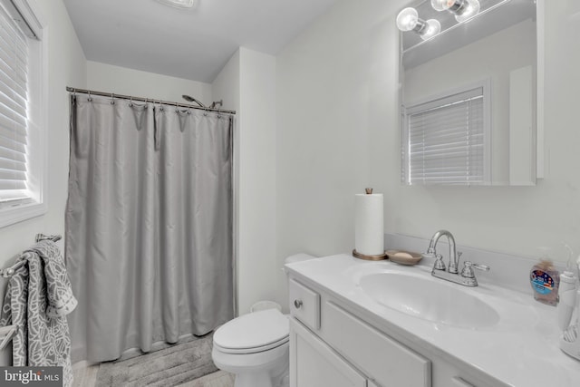 bathroom with vanity, toilet, and walk in shower