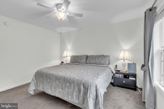 bedroom with ceiling fan, light colored carpet, and multiple windows