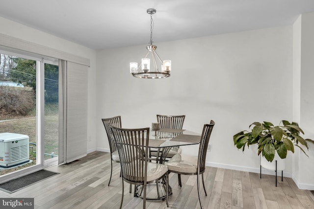 dining room with a chandelier, light wood-type flooring, and plenty of natural light