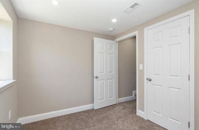 unfurnished bedroom featuring light carpet