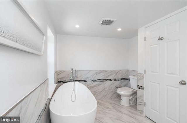 bathroom featuring toilet, tile walls, and a tub