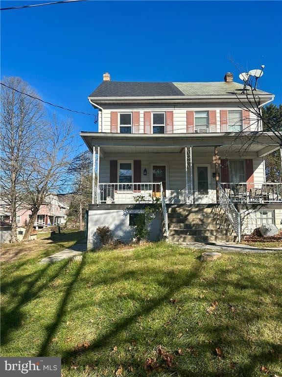 view of front of property featuring a front lawn and a porch