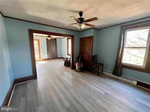 interior space with a textured ceiling, light hardwood / wood-style flooring, baseboard heating, and ornamental molding