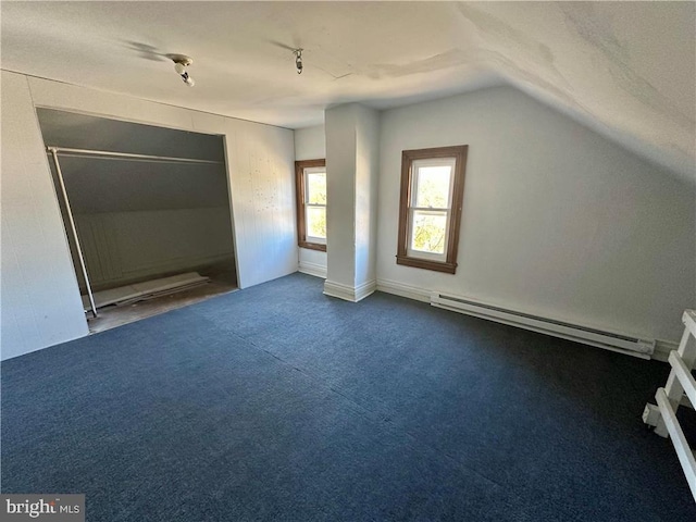 additional living space featuring carpet flooring, vaulted ceiling, and a baseboard heating unit