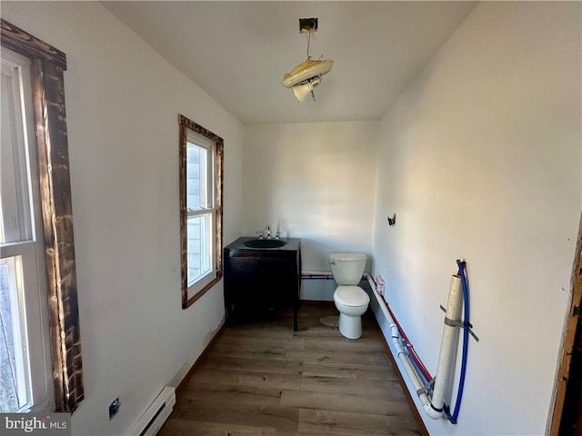 bathroom featuring hardwood / wood-style flooring, vanity, toilet, and a baseboard radiator