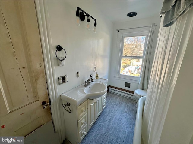 bathroom with vanity, toilet, and baseboard heating