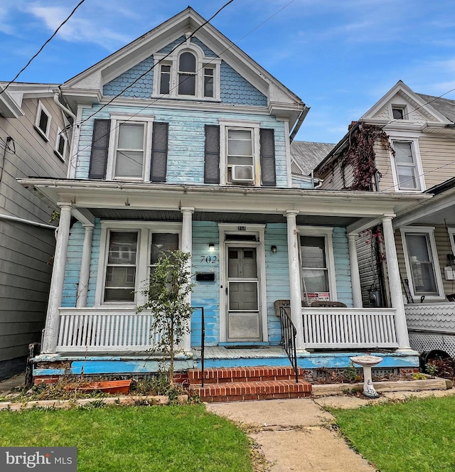 victorian-style house with a porch and cooling unit