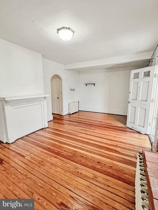 interior space with radiator heating unit and light hardwood / wood-style flooring