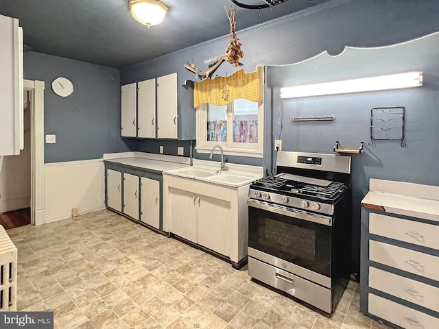 kitchen with white cabinets, stainless steel range with gas cooktop, and sink