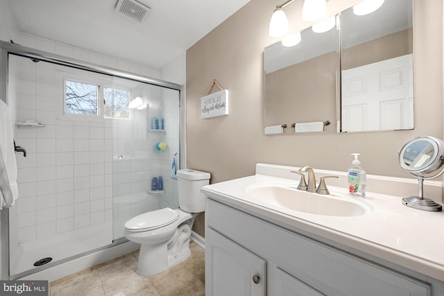 bathroom featuring toilet, vanity, tile patterned flooring, and a shower with shower door