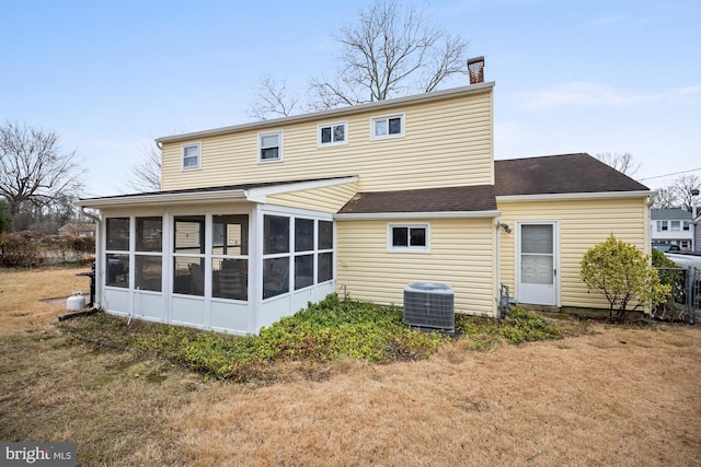 rear view of house featuring central AC, a yard, and a sunroom