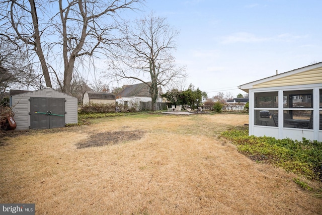 view of yard with a sunroom and a storage unit