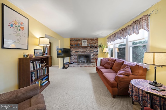 living room with a brick fireplace and carpet floors