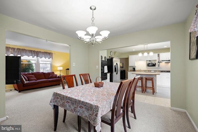 carpeted dining area featuring a chandelier