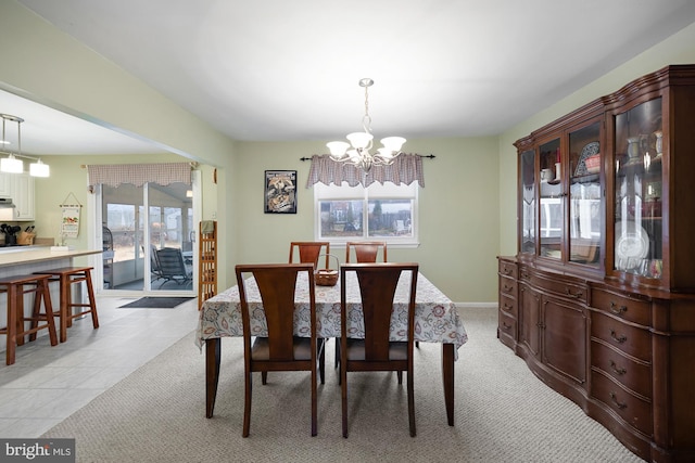 carpeted dining space with a chandelier