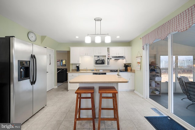 kitchen with white cabinets, a kitchen island, sink, hanging light fixtures, and stainless steel fridge with ice dispenser