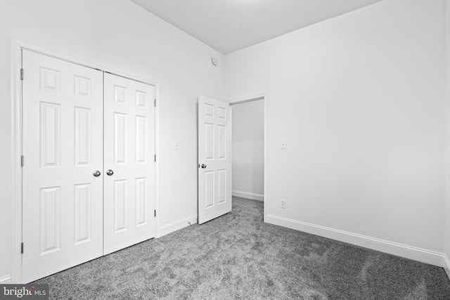 unfurnished bedroom featuring carpet flooring and a closet