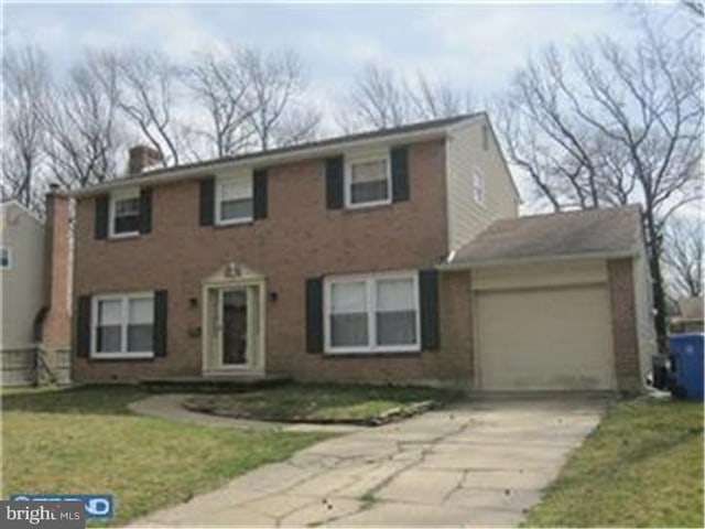 view of front of property with a garage and a front lawn