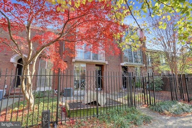 251 W Lafayette Ave, Baltimore, MD 21217 - view of front facade with brick siding, a fenced front yard, central AC, and a gate