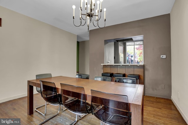 dining space featuring hardwood / wood-style floors and a notable chandelier