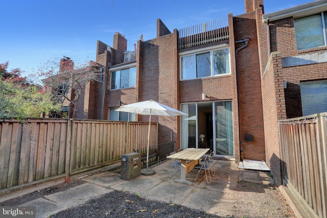 251 W Lafayette Ave, Baltimore, MD 21217 - rear view of property featuring a patio, brick siding, and a fenced backyard